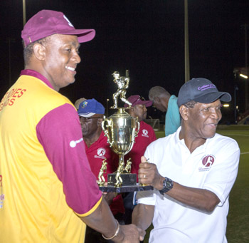 Courtney Walsh (left) collects the winning trophy from Lawrence Rowe.