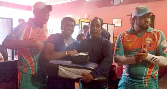 Alix Husain is presented with cricket gears from members of the Sunrise Softball Cricket Club and their sponsor.