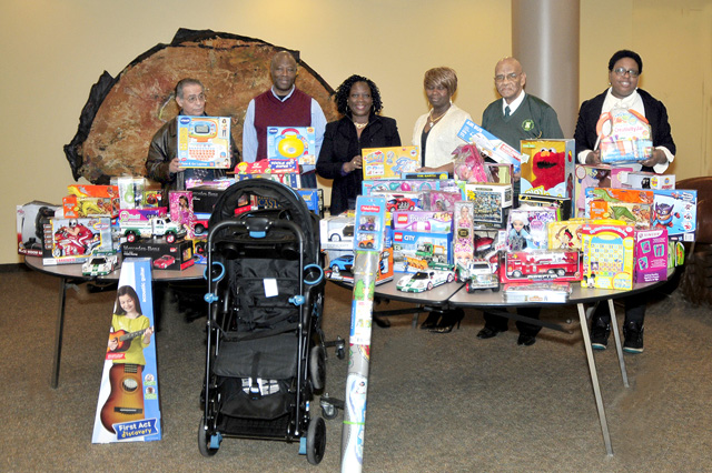 Some of the toys, including a stroller presented to COPE. (L to R) Joe Namy, Keith Aaron, Stephanie Power, Alma Riley, Leslie Lewis and Erica Monroe.
