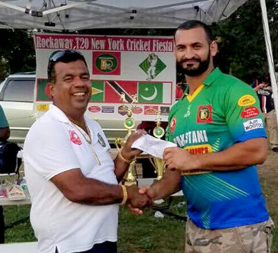 Abdullah Syed, MVP of the final (right), collects his check for the nine sixes he struck which earned him $180.00.
