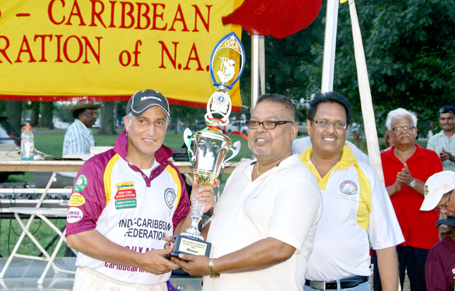 Amjad Khan, captain of the Caribbean Invitation XI team receiving the winning trophy from Kawal Narain of Jemtex Sports USA. 