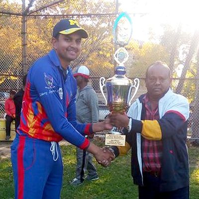 Captain Danesh Deonarain collects the 2016 EACA T20 Championship trophy from James Manbahal.